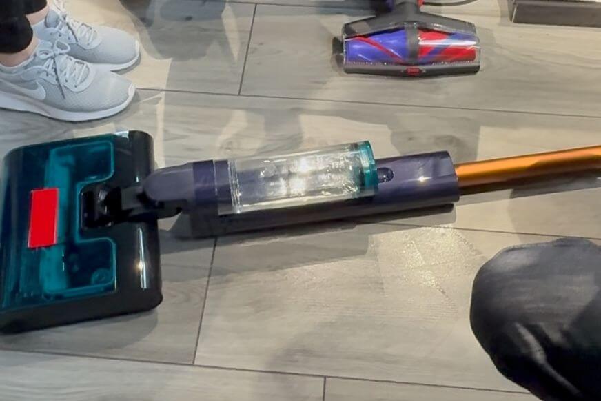 Dyson Clean+Wash Hygiene liegt komplett flach auf dem Boden und reinigt mühelos unter einem Sofa